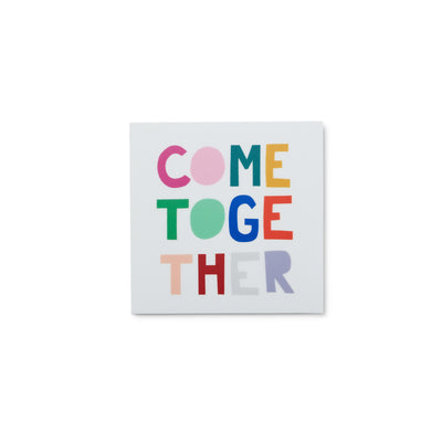 white square sticker with colorful cut paper letters reads Come Together