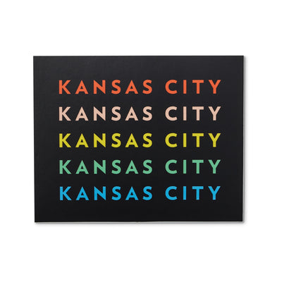 black sticker with Kansas City repeated in rainbow colors