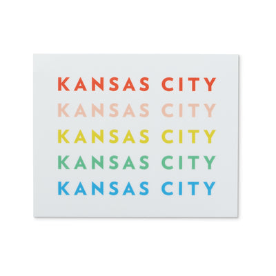 white sticker with Kansas City repeated in rainbow colors