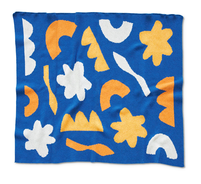 royal blue throw blanket with yellow orange and white cut paper shapes