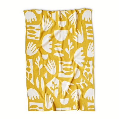 citrine throw blanket with white cut paper shapes